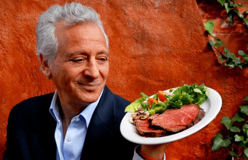 Pierre Dukan memegang sepinggan produk protein